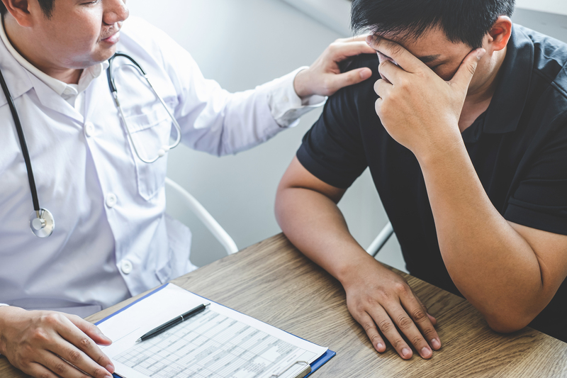 Image of doctor holding patient's hand to encourage, talking with patient cheering and support.