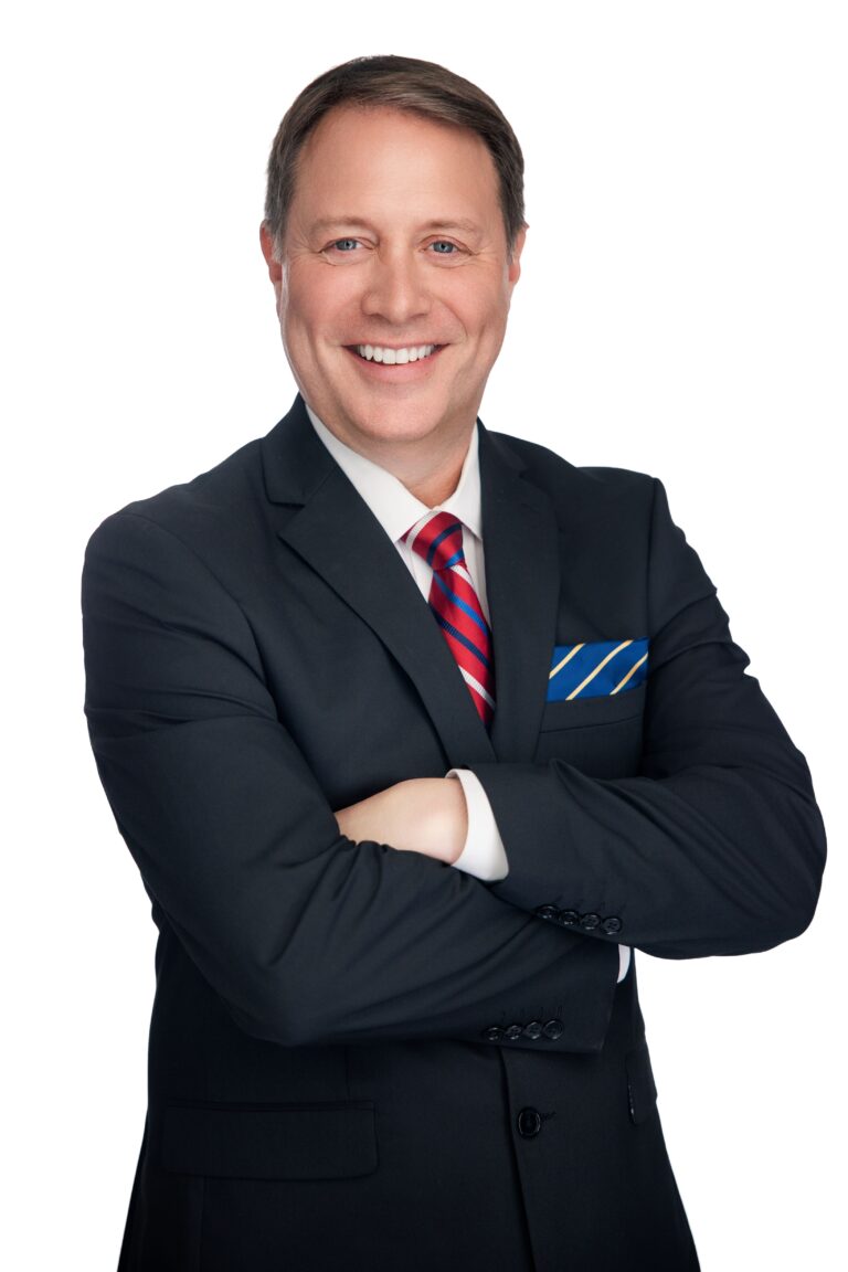 Attorney Brian Smith in a professional headshot, dressed in a black suit and red tie, confidently posing for his legal profile.