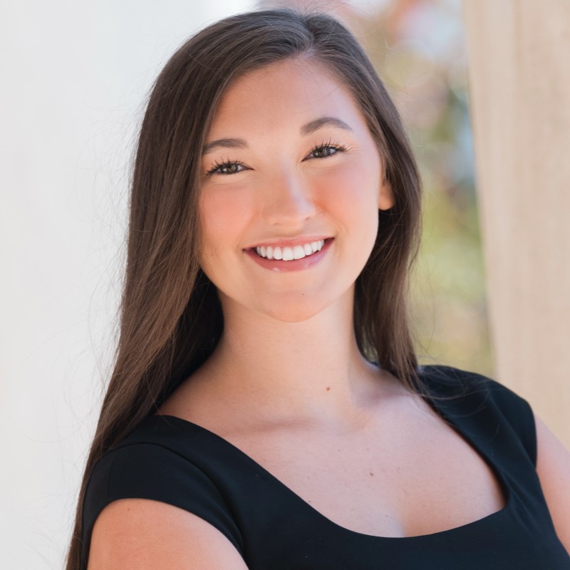 Professional headshot of South Carolina Attorney Kiona Corwin, smiling in a black top against an outdoor setting.